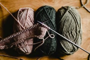 drei Wollknäule mit Strickteil